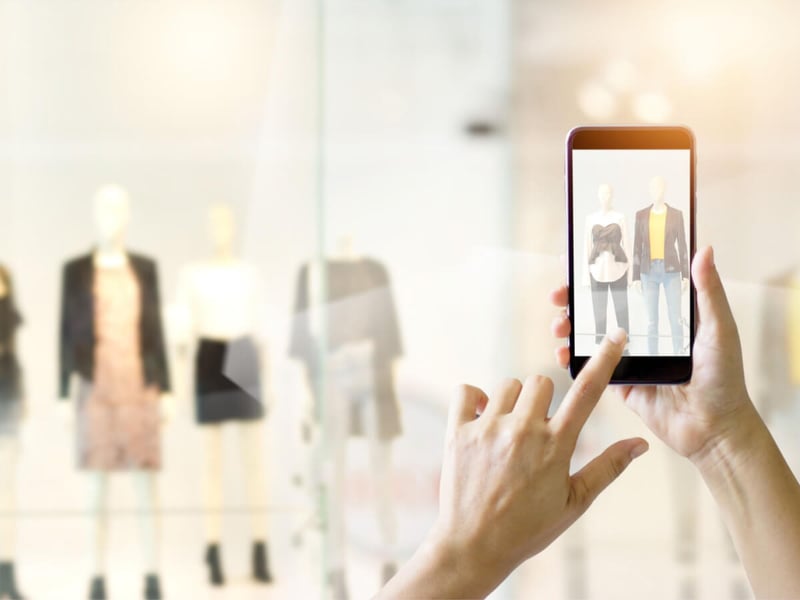 A-person-with-smartphone-taking-photo-of-clothing-store