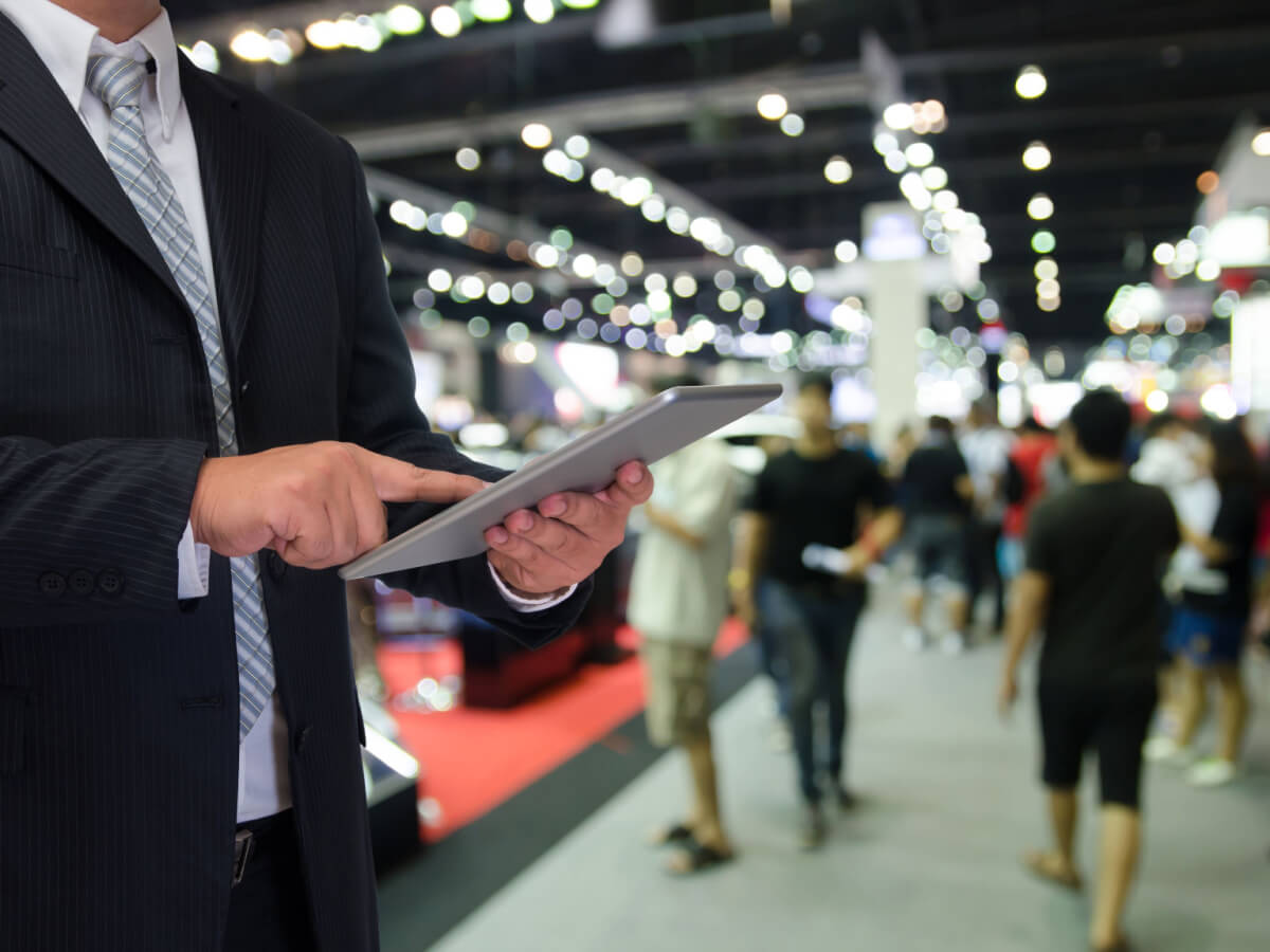 Businessman using technology during tradeshow event. 
